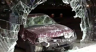 Un escaparate destrozado por un coche en un alunizaje.