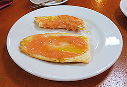 Una barrita de desayuno con aceite y tomate.