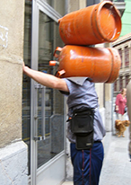 Un butanero llamando a una puerta para hacer la entrega.