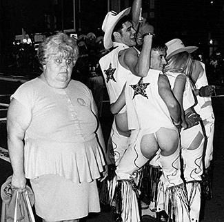 Una señora ojiplática junto a uno neovaqueros gays.