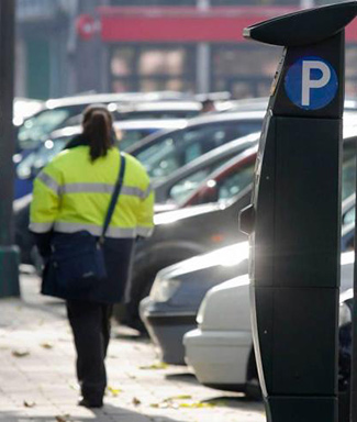 Una vigilante de la ORA con su típico impermeable amarillo y azul.