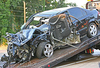 Un coche siniestro total sobre una grua.