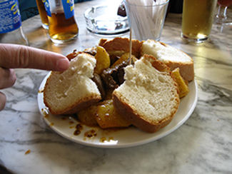 Una tapa de carne con patatas y algo de pan.